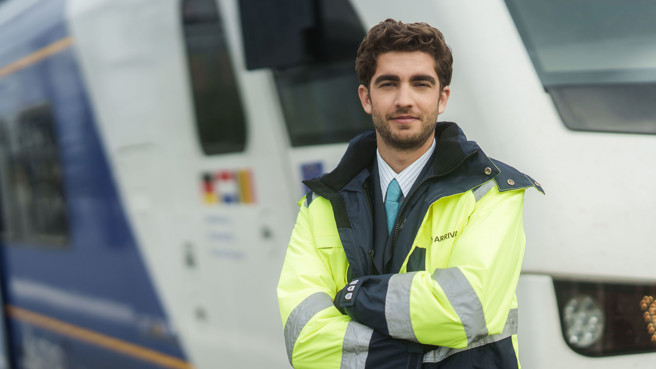 Machnist van Arriva staat met de armen over elkaar voor een trein. Machnist van Arriva staat met de armen over elkaar voor een trein.