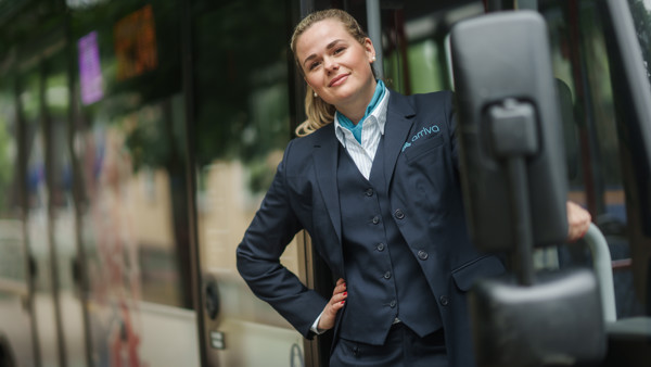 Buschauffeur hangt uit haar bus van Arriva en kijkt lachend in de camera. Buschauffeur hangt uit haar bus van Arriva en kijkt lachend in de camera.