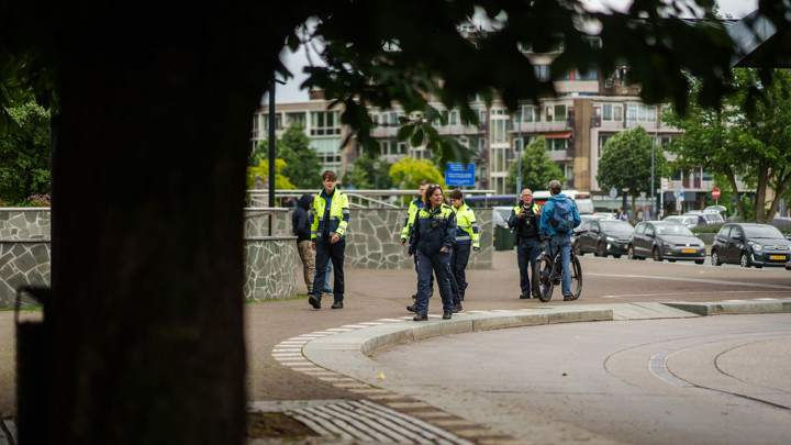 Een groep veiligheidsmedewerkers in uniform loopt buiten over een trottoir, met stedelijke gebouwen en geparkeerde auto’s op de achtergrond. Een groep veiligheidsmedewerkers in uniform loopt buiten over een trottoir, met stedelijke gebouwen en geparkeerde auto’s op de achtergrond.