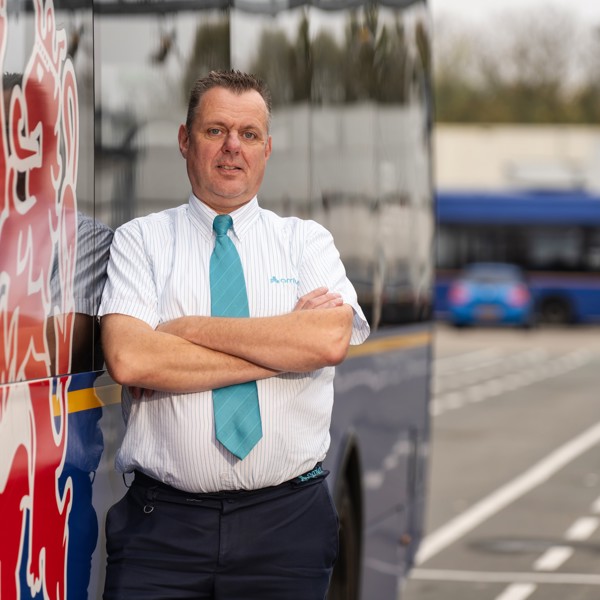 Buschauffeur van middelbare leeftijd staat voor een bus van Arriva Buschauffeur van middelbare leeftijd staat voor een bus van Arriva