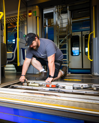 Monteur werkt aan de deuropening van de trein Monteur werkt aan de deuropening van de trein