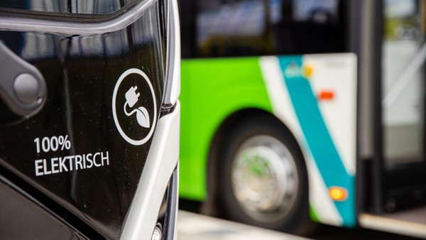 Arriva-bus met logo voor 100% elektrisch rijden. op de achtergrond staat nog een wit-groene Arriva bus.