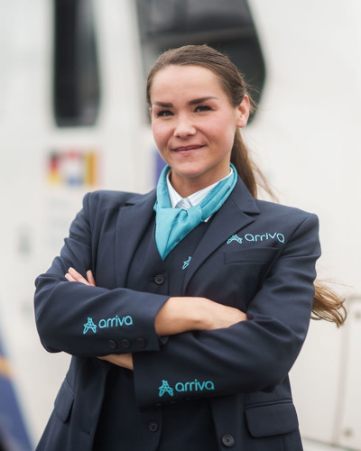Machinist van Arriva staat lachend met de armen over elkaar voor haar trein. Machinist van Arriva staat lachend met de armen over elkaar voor haar trein.